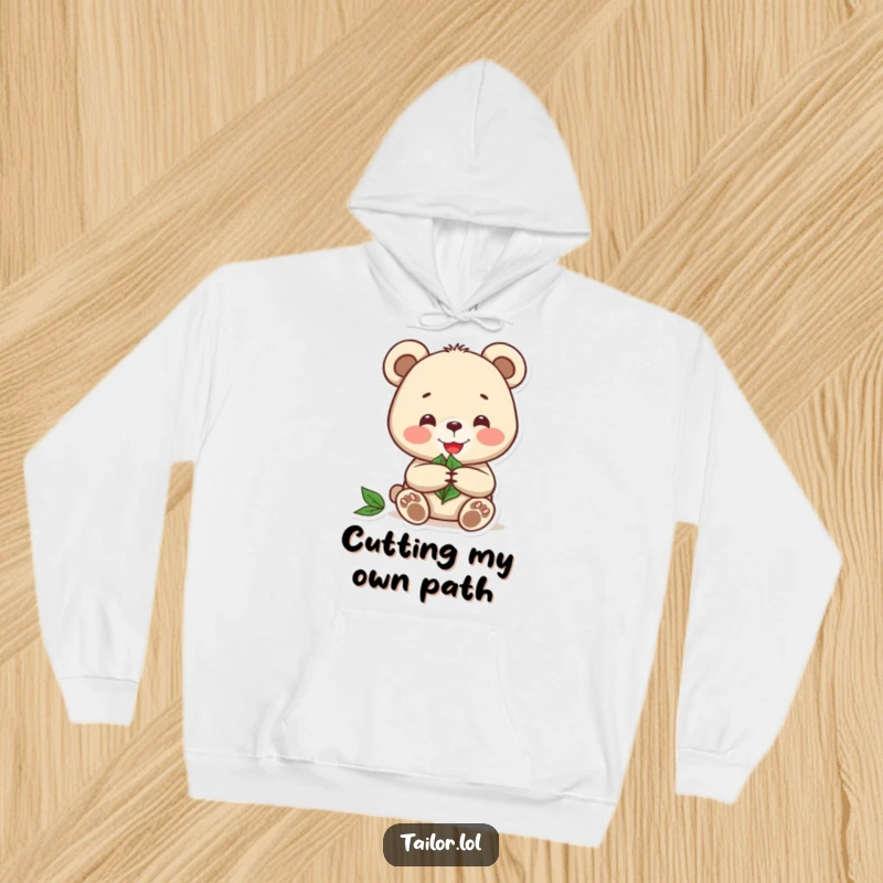 Funny hoodie of a joyful bear engrossed in cutting a pattern from a leaf, perfect for cozy nature vibes.